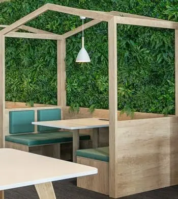 a table and bench in a room with green plants