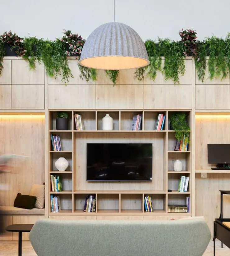 a person walking in a room with a tv and shelves